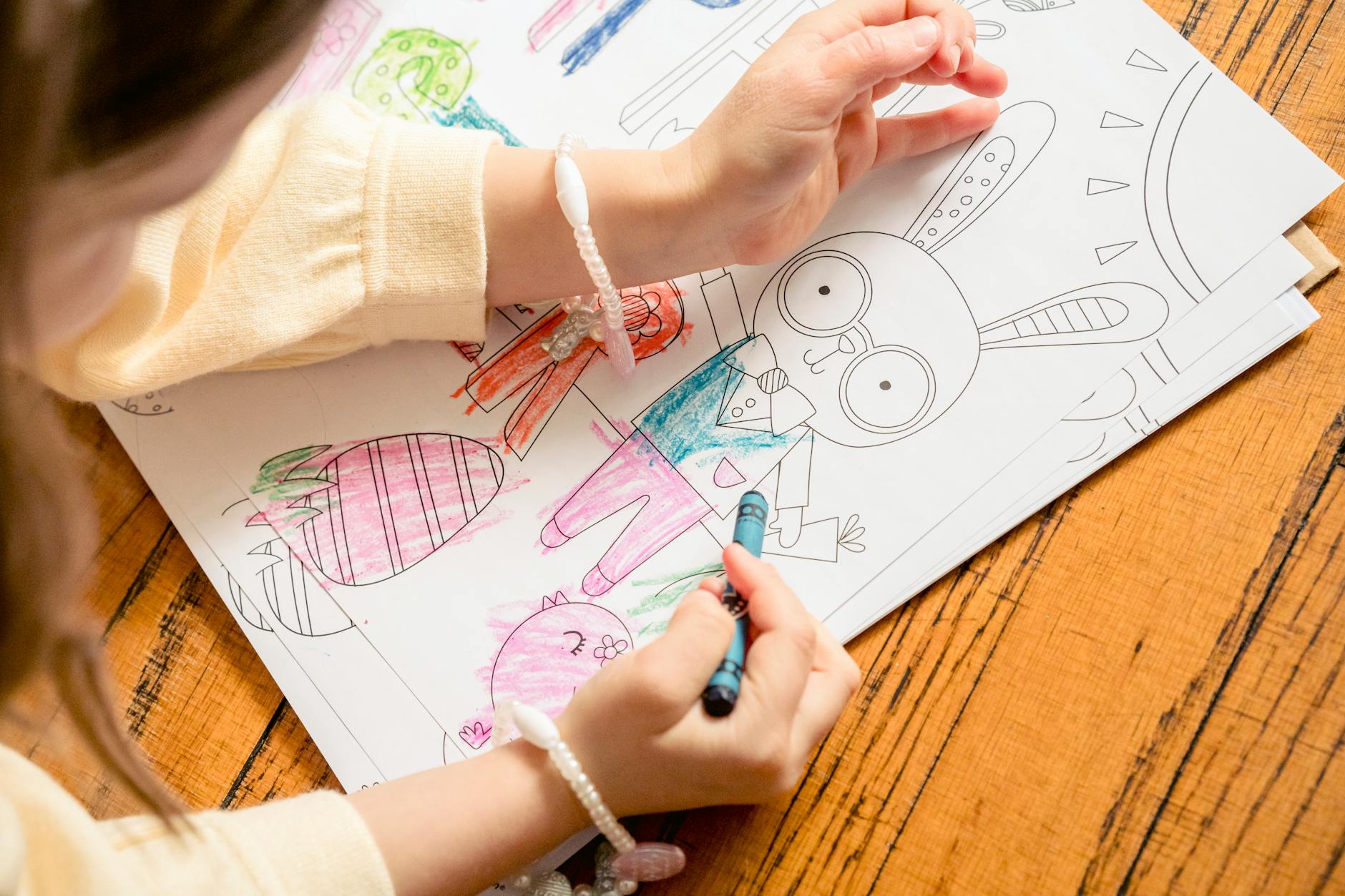 girl painting in coloring book in daytime